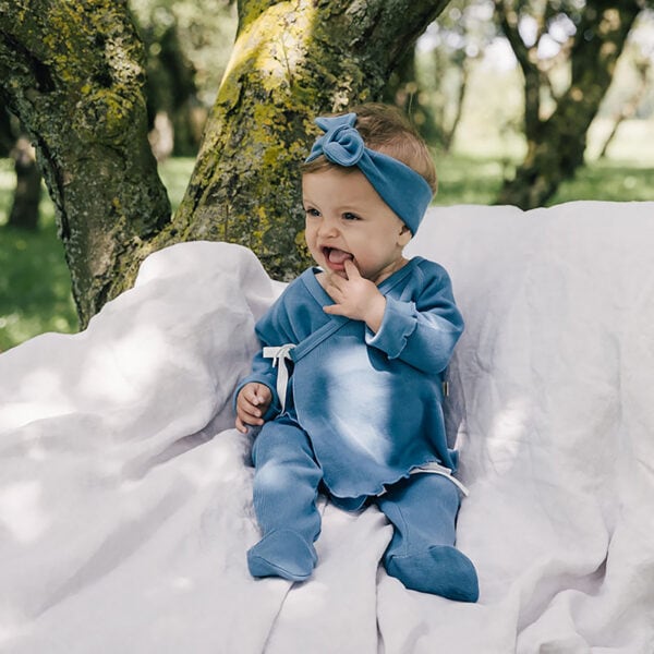 Baby wearing outfit and bow in pima cotton | UAUA Collections