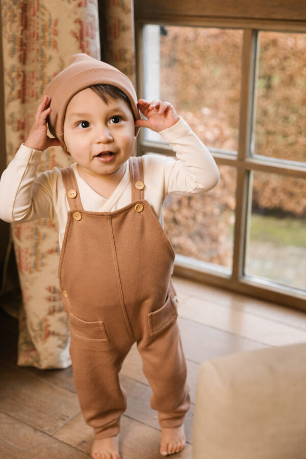 Toddler wearing overall and hat in pima cotton - biscotti - Puno Collection | UAUA Collections